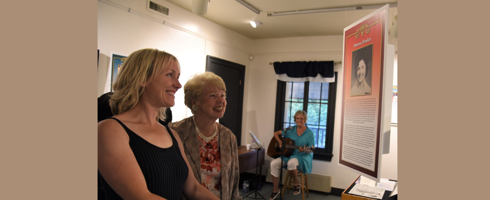 Two women looking at a image of one of the Remarkable Women nominated in 2022