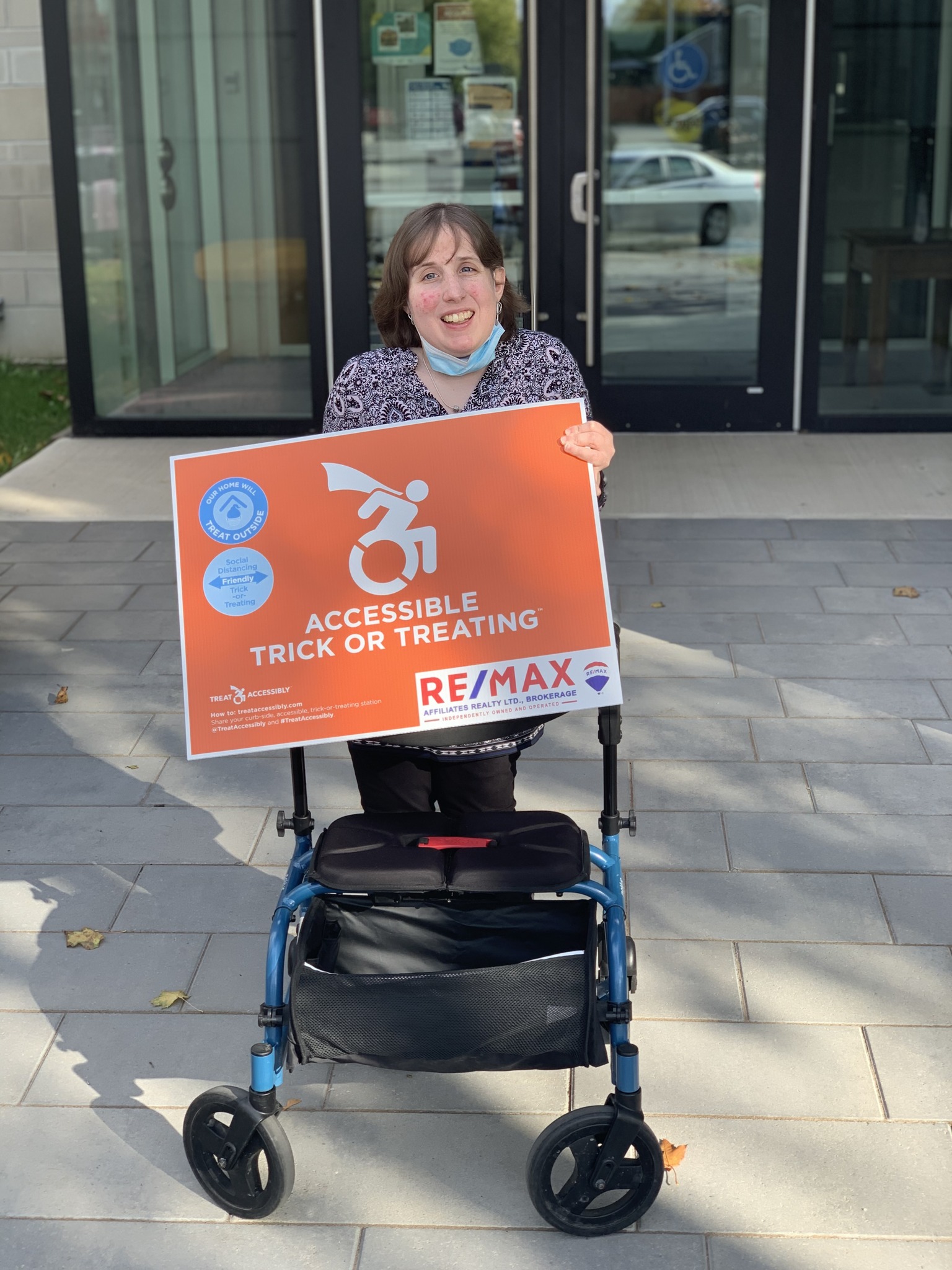 Chair of Accessibility Advisory Committee holding an accessible trick or treat sign