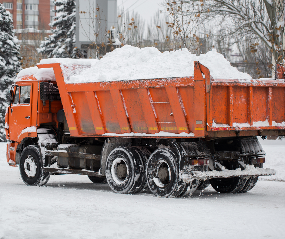 Orange dump truck with snow