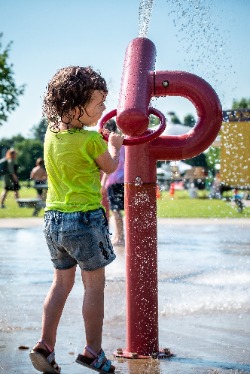 young child playing in splash pad