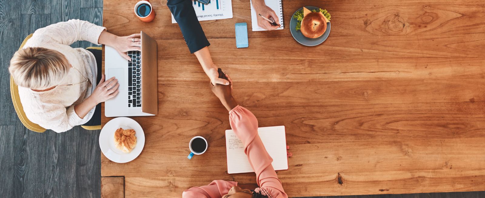 handshake between two people across table