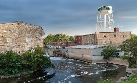 Two buildings joined by a bridge over flowing water