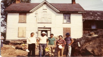 people standing outside home under construction
