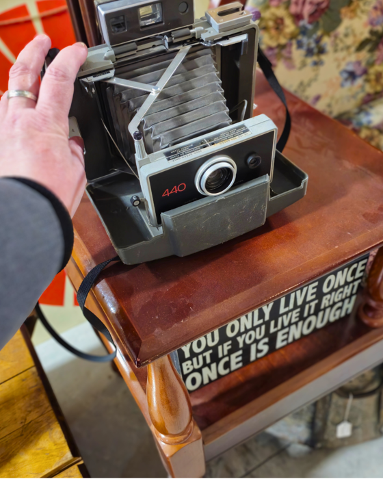 A woman looks at an old camera at Bernie's Nearly New.
